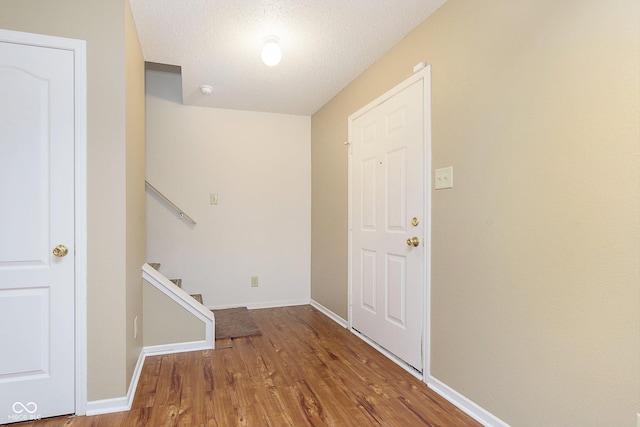 interior space featuring wood-type flooring and a textured ceiling