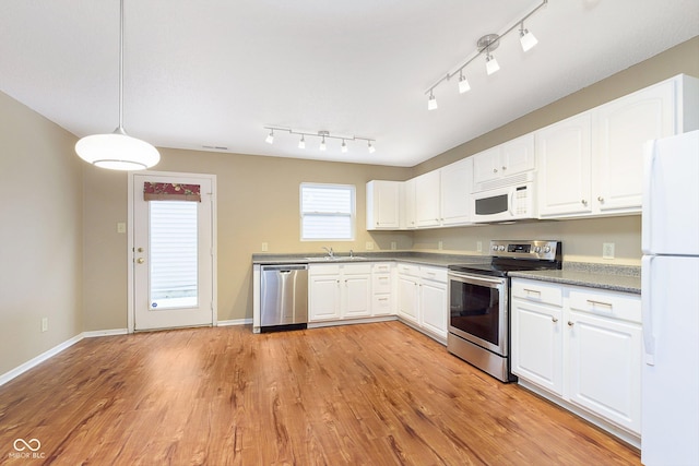 kitchen with pendant lighting, white cabinets, stainless steel appliances, light hardwood / wood-style floors, and sink