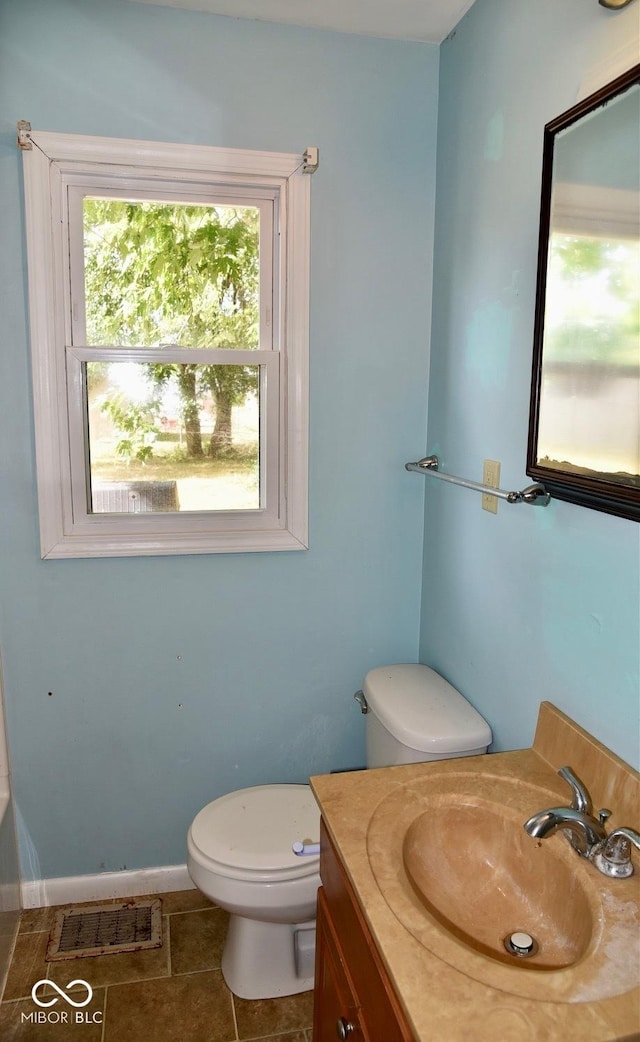 bathroom with toilet, vanity, and tile patterned floors