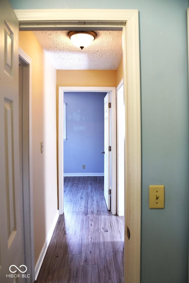 corridor featuring dark hardwood / wood-style floors and a textured ceiling