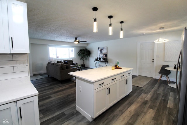 kitchen with stainless steel fridge, white cabinetry, a textured ceiling, dark hardwood / wood-style flooring, and decorative light fixtures