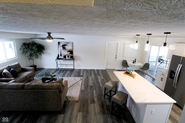 living room featuring a wealth of natural light, dark hardwood / wood-style floors, and a textured ceiling