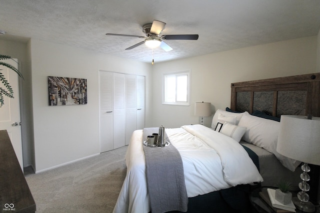 carpeted bedroom featuring ceiling fan, a textured ceiling, and a closet