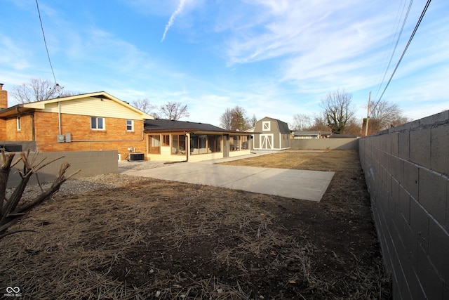 view of yard featuring cooling unit, an outdoor structure, and a patio area