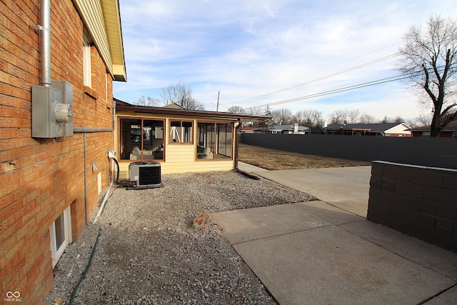 view of yard featuring a patio area, a sunroom, and central air condition unit