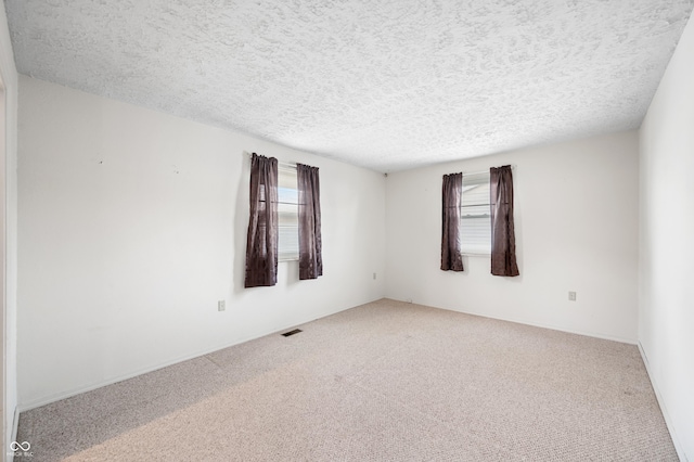 carpeted spare room featuring a textured ceiling