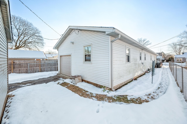 view of snow covered exterior featuring a garage