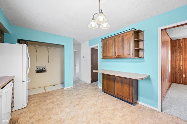 kitchen featuring decorative light fixtures, a textured ceiling, and white refrigerator