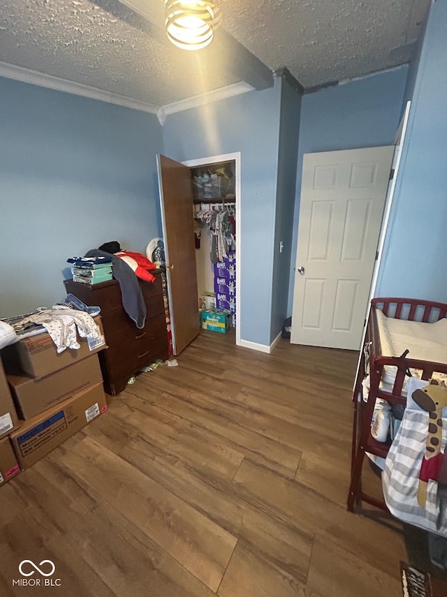 bedroom with hardwood / wood-style floors, ornamental molding, a closet, and a textured ceiling