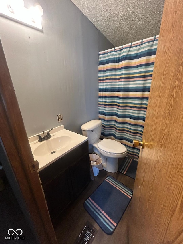 bathroom with vanity, toilet, a textured ceiling, and a shower with shower curtain