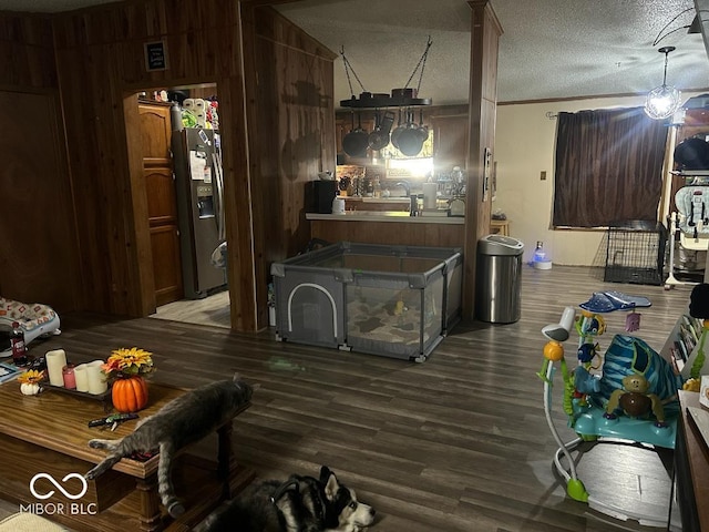 kitchen with hardwood / wood-style flooring, ornamental molding, a textured ceiling, and stainless steel refrigerator with ice dispenser