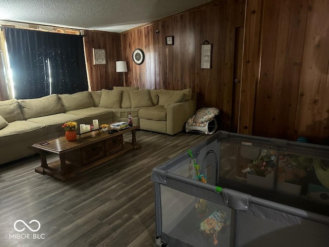 living room with dark hardwood / wood-style flooring, wooden walls, and a textured ceiling