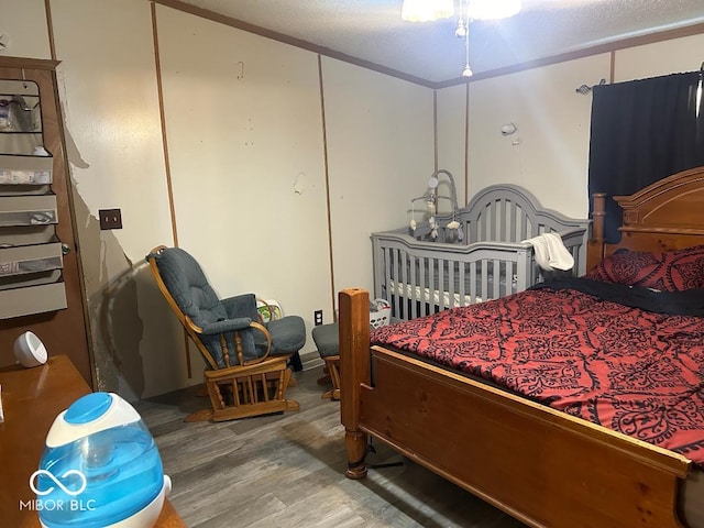 bedroom with a crib and hardwood / wood-style floors