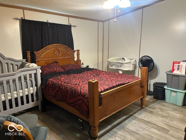 bedroom featuring wood-type flooring and a textured ceiling