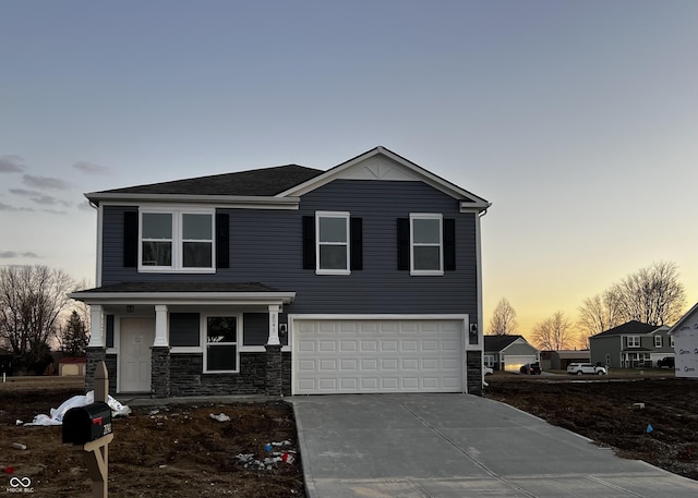 view of front facade featuring driveway, stone siding, and an attached garage