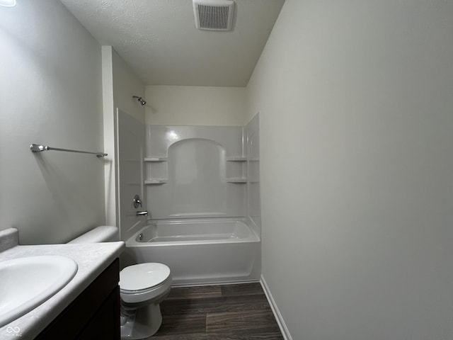 bathroom with visible vents, toilet, wood finished floors, vanity, and washtub / shower combination