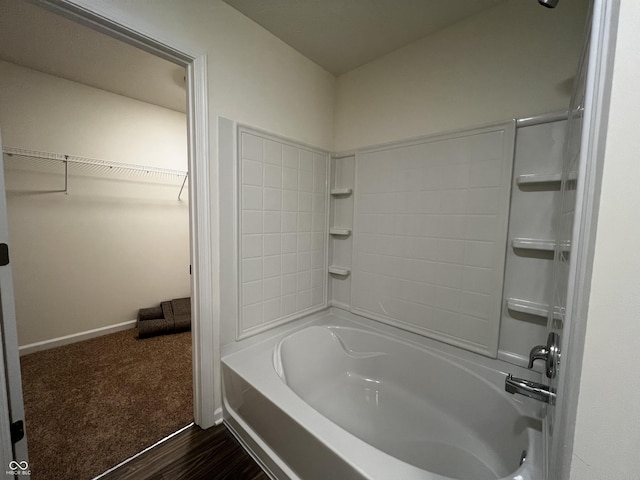 full bath with a walk in closet, shower / bathing tub combination, and baseboards