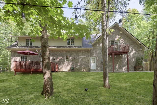 rear view of property featuring a wooden deck and a lawn