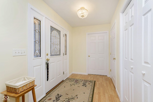 foyer entrance featuring a chandelier and light hardwood / wood-style floors