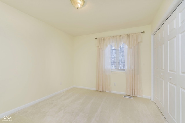 unfurnished room featuring light colored carpet