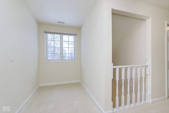 spare room featuring light carpet