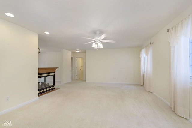 unfurnished living room featuring ceiling fan and light carpet