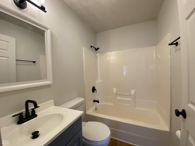 full bathroom featuring toilet, vanity, tub / shower combination, and a textured ceiling