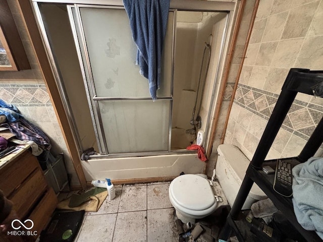 full bathroom with tile patterned floors, vanity, tile walls, toilet, and combined bath / shower with glass door