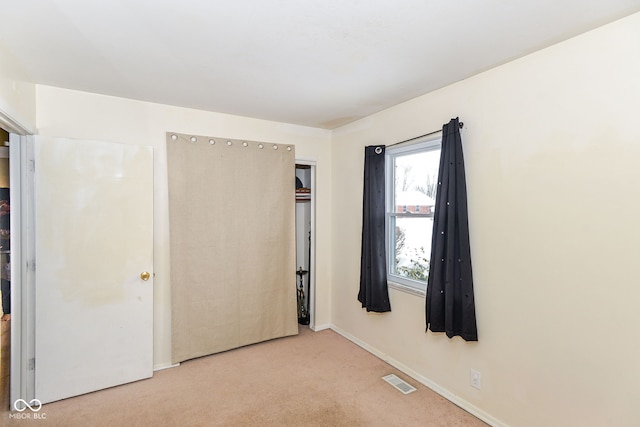 unfurnished bedroom featuring light carpet