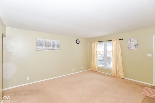 spare room featuring light colored carpet