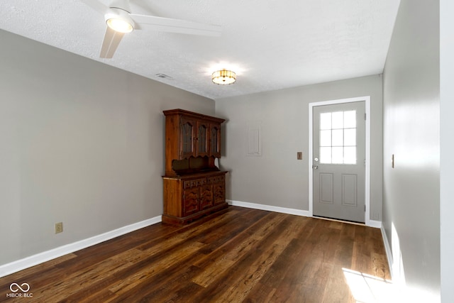 foyer with ceiling fan, a textured ceiling, and dark hardwood / wood-style flooring