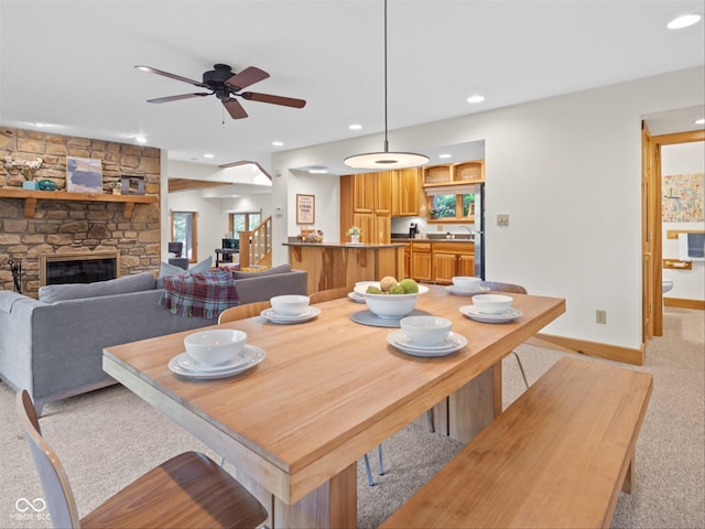 carpeted dining room with sink and a fireplace