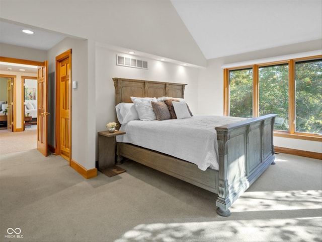 bedroom with light colored carpet and high vaulted ceiling