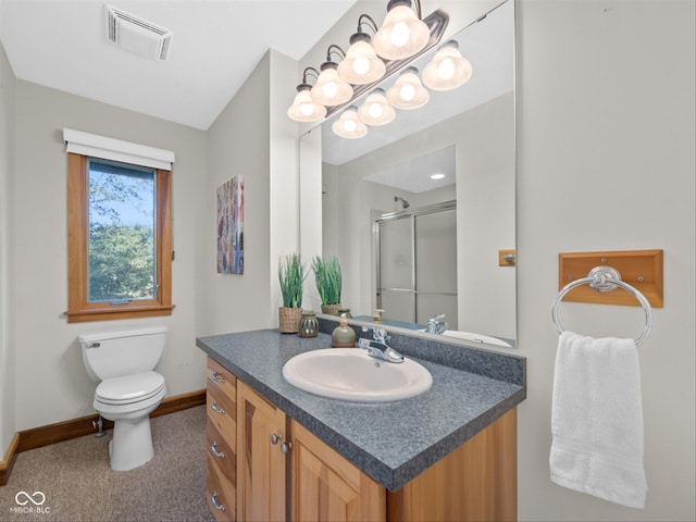 bathroom featuring a shower with door, vanity, and toilet