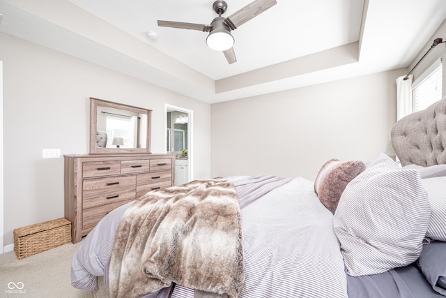 bedroom with ceiling fan, a tray ceiling, and carpet floors