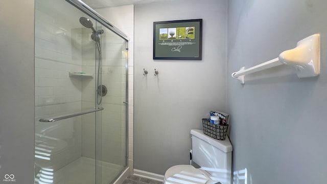 bathroom with a shower with door and toilet