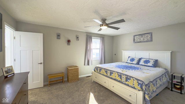 bedroom with ceiling fan, a textured ceiling, and dark colored carpet