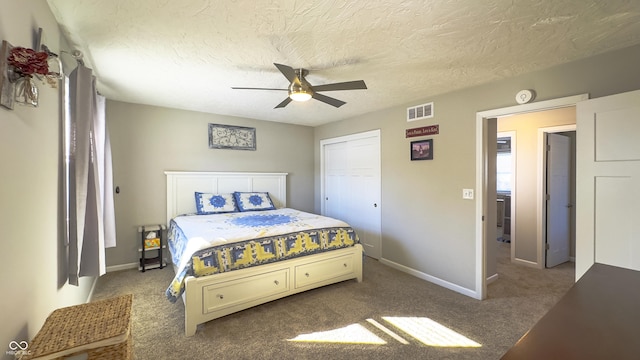 carpeted bedroom featuring ceiling fan, a textured ceiling, and a closet