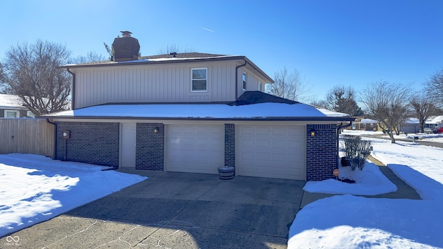 view of snowy exterior featuring a garage