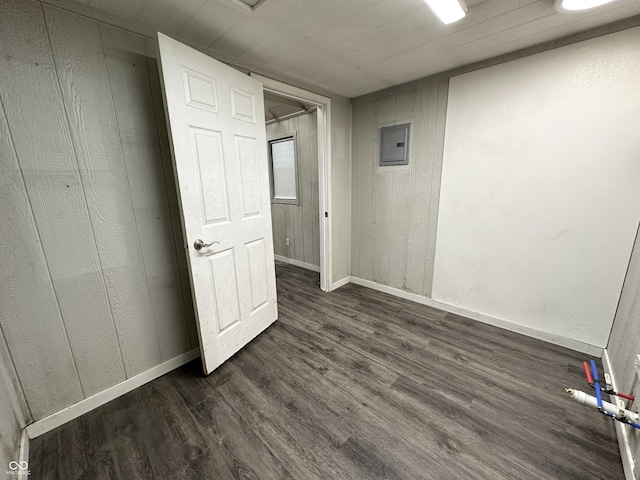 spare room featuring dark wood-type flooring and electric panel