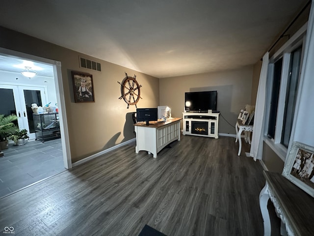 living room with a fireplace, french doors, and dark hardwood / wood-style flooring