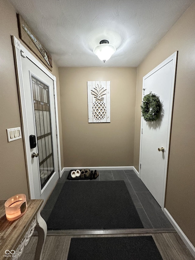 doorway with dark tile patterned flooring