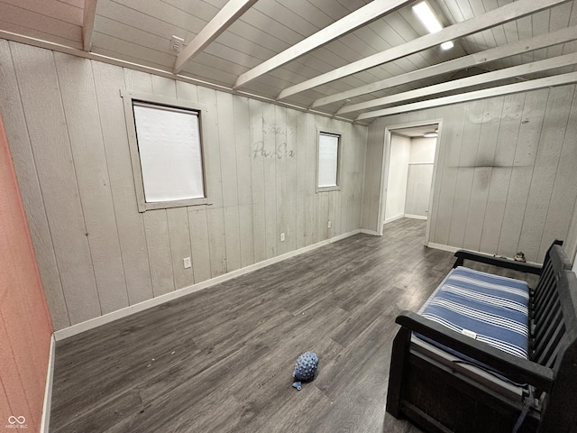 interior space with beam ceiling, dark hardwood / wood-style flooring, wood walls, and wooden ceiling