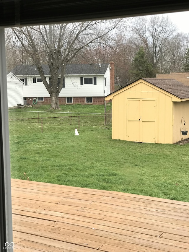 view of yard featuring a wooden deck and a storage unit