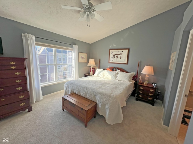 bedroom featuring ceiling fan, lofted ceiling, light carpet, and a textured ceiling