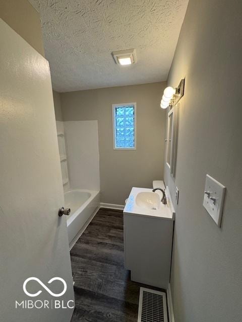 bathroom with vanity, a textured ceiling, and hardwood / wood-style floors