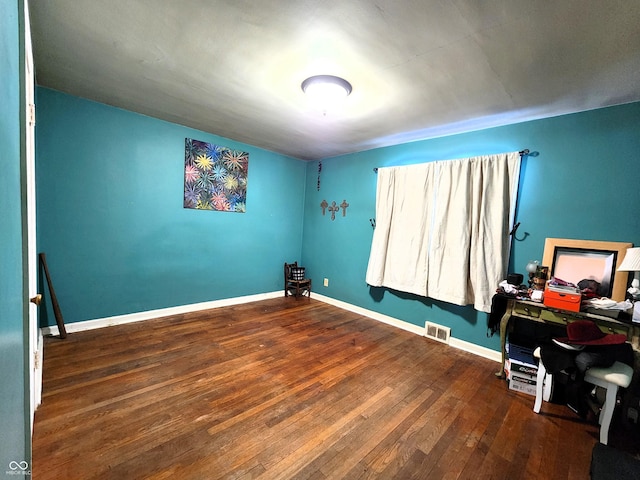 home office with baseboards, visible vents, and wood-type flooring