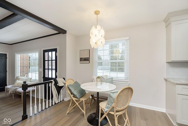 dining space featuring an inviting chandelier, a wealth of natural light, and light hardwood / wood-style flooring