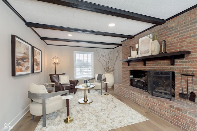 living room with a fireplace, beam ceiling, and light wood-type flooring