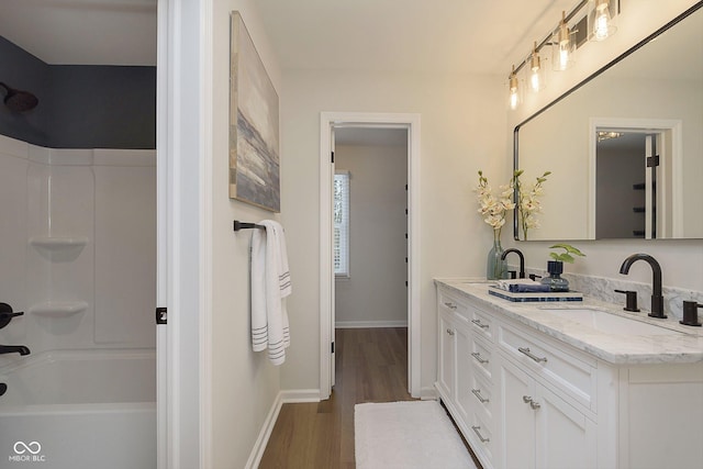 bathroom featuring hardwood / wood-style flooring, vanity, and  shower combination